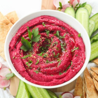 dairy free beetroot hummus appetizer dip with pita bread and sliced cucumbers