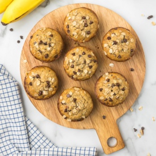 Gluten Free Banana Chocolate Chip Muffins on a circular wooden platter