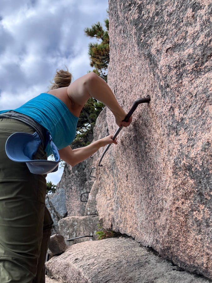 using iron rungs to climb up the beehive hike