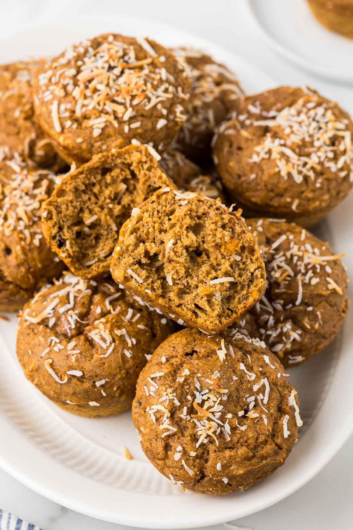 a pile of whole wheat sweet potato muffins with coconut on a white plate
