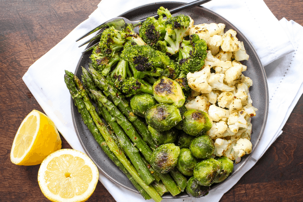 roasted vegetables on a plate with lemon