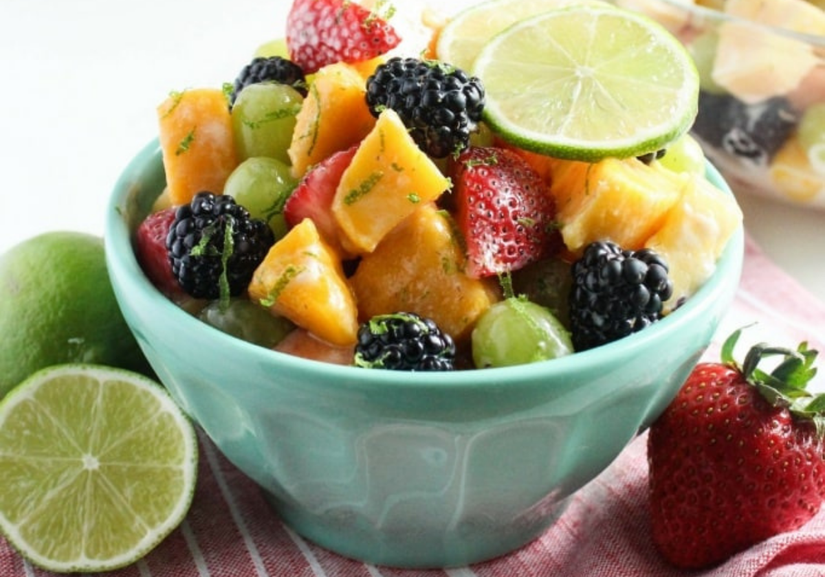 fruit salad in a blue bowl with lime slices