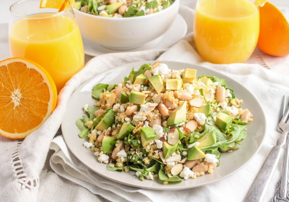 avocado quinoa salad with sliced oranges around it