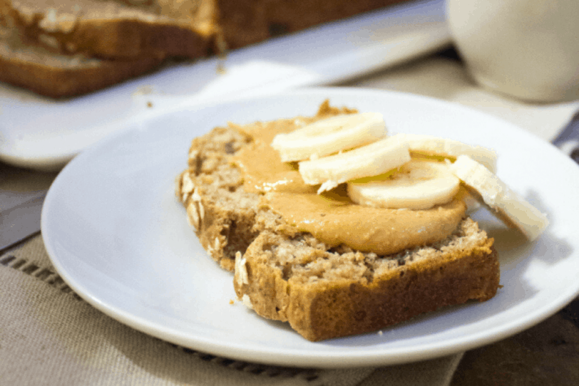 slice of whole wheat peanut butter banana bread (made with overripe bananas) on a white plate
